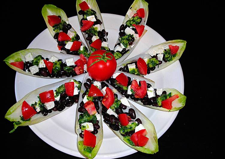 Foto principal de Pétalos de endibias con alubias negras, tomates y queso de cabra