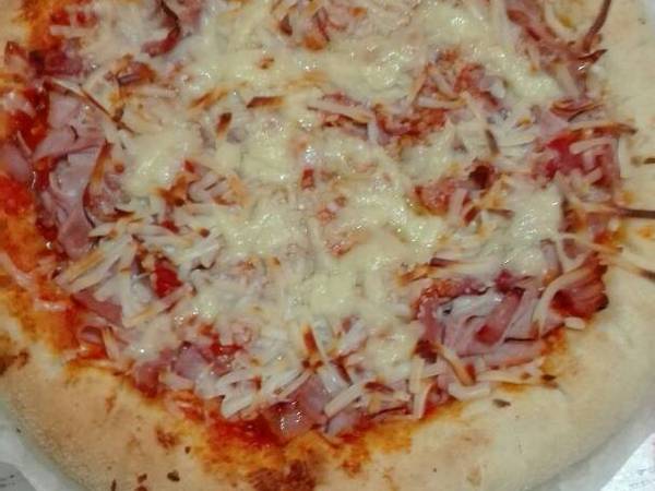 Pizza de jamón york glaseado y beicon con el borde relleno de queso