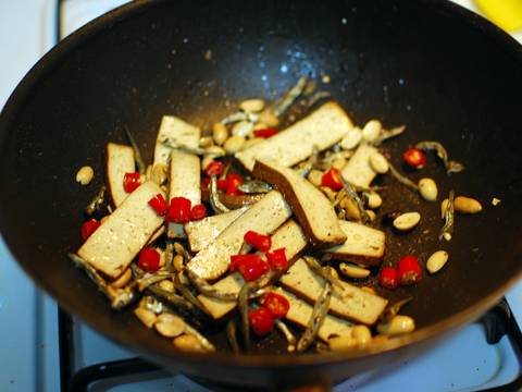 豆製品料理 炒 熱油鍋後,依序將豆乾,豆豉,小魚乾,辣椒以及花生倒進去