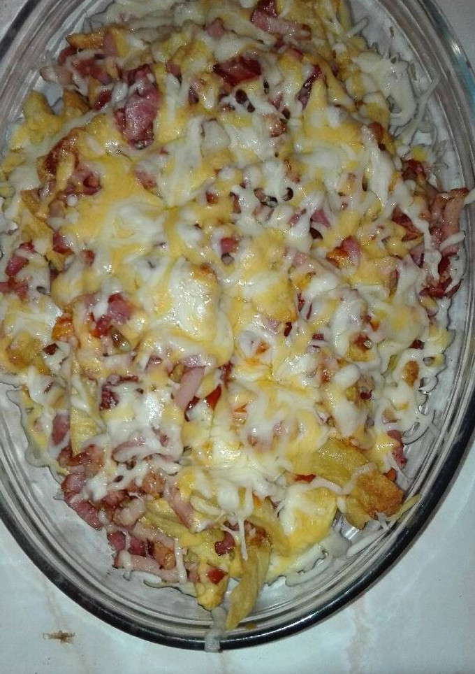 Una foto de Patatas bravas con beicon salchichas con cuatro quesos