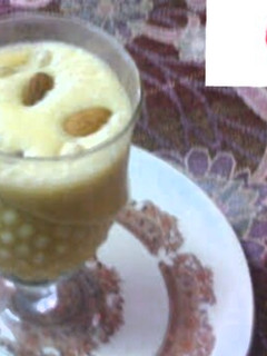 A picture of Mango shake with ice cream and dry fruits.