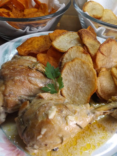 Una foto de Pollo con crema de naranja con rodajas de patatas y batatas crujientes