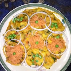 A picture of Yam porridge garnish with grated carrots, onions and peas.