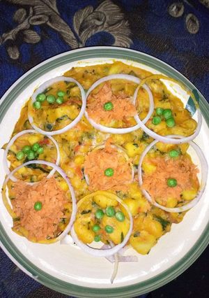 A picture of Yam porridge garnish with grated carrots, onions and peas.
