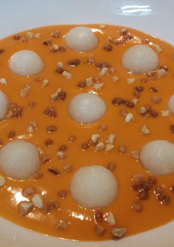 Una foto de Salmorejo con esferas de melón y almendras crocanti