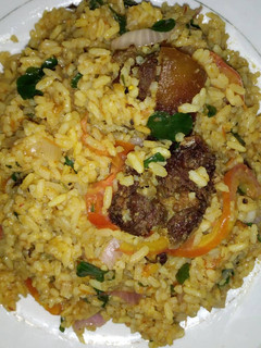 A picture of Jollof vegetable rice with fried meat.