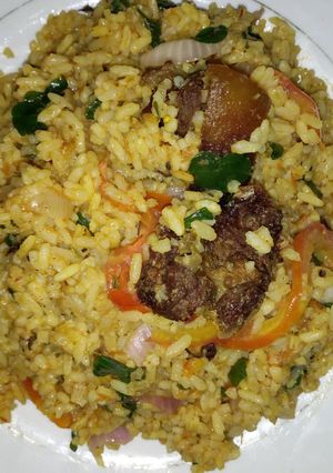 A picture of Jollof vegetable rice with fried meat.
