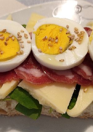 Foto principal de Tosta de rúcula, queso, jamón y huevo