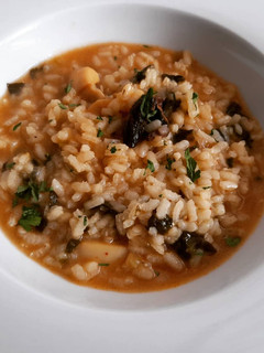 Una foto de Arroz caldoso de sepia, rape, setas y espinacas
