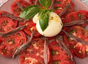 Una foto de Carpaccio de tomate con burrata y anchoas