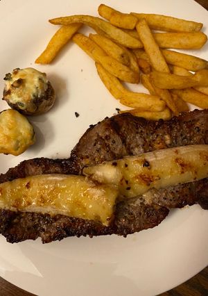 A picture of 🥰Dinner for 2 date night 😍Grilled steak, wt (grilled banana)stuffed spinach mushrooms and fries❤️.