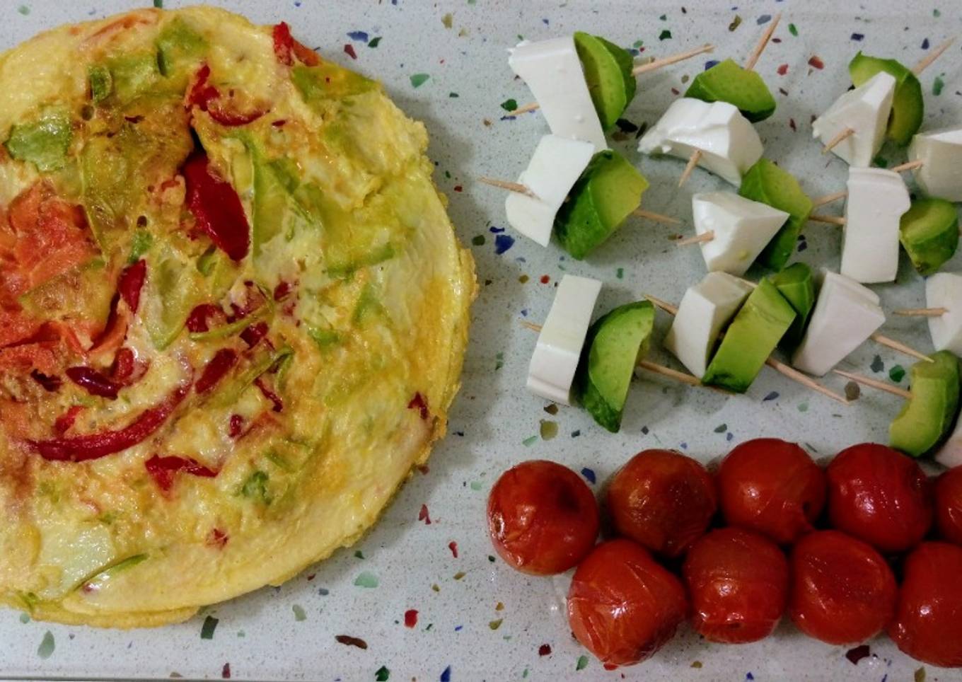 Tortilla de verduras, tomatitos asados y pinchitos de aguacate con queso