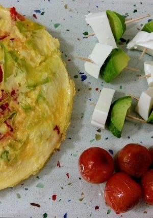 Una foto de Tortilla de verduras, tomatitos asados y pinchitos de aguacate con queso