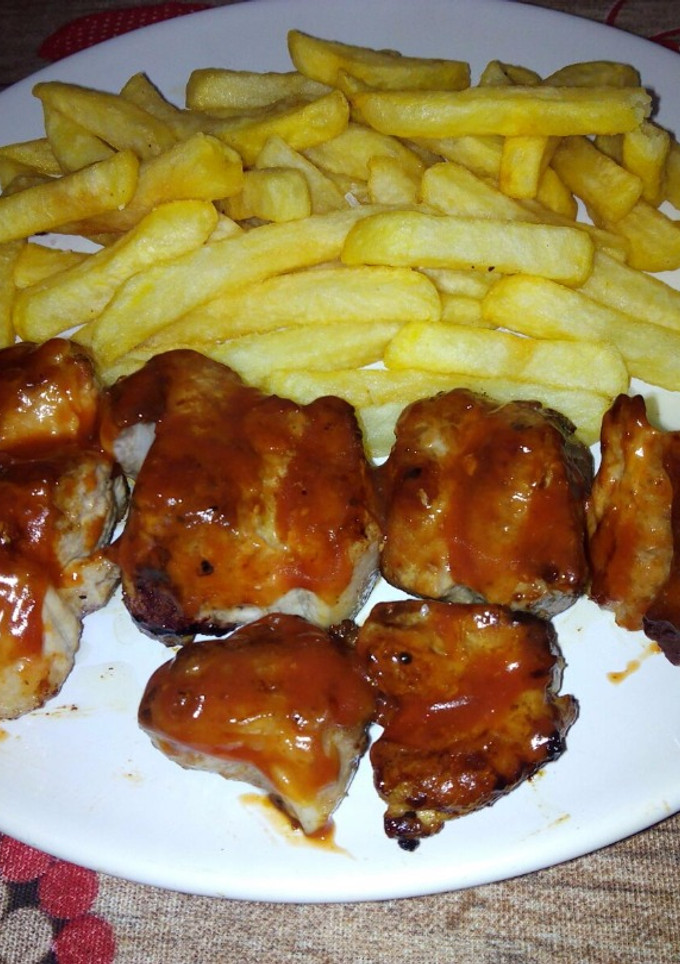 Una foto de Costillitas de cerdo con salsa barbacoa y patatas fritas🍖🍟