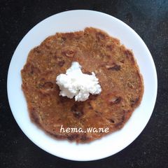 A picture of Arrowroot mix thalipeeth with white butter.