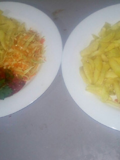 A picture of Oven baked fries,salad,tomato onion source.