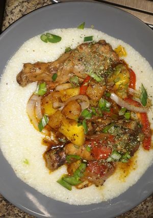 A picture of Sweet & Spicy Pineapple chicken legs on grits.