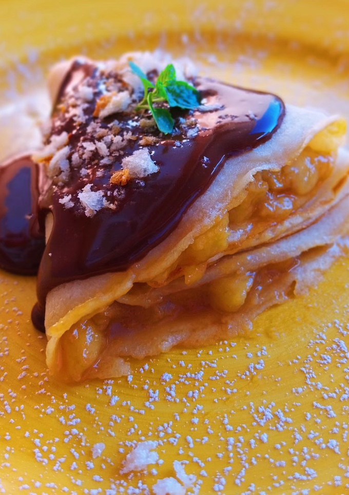 Una foto de Crepes de plátano caramelizado y ganache de chocolate
