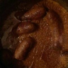 A picture of Pork sausages in gravy.