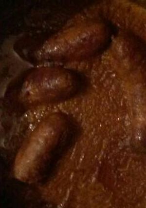 A picture of Pork sausages in gravy.