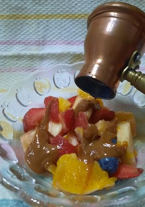 Una foto de Ensalada de frutas con salsa de dulce de leche y algo más.