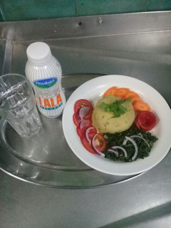 A picture of Mashed Matoke, fried sukumawiki, Raw carrots n tomatoes.