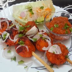 A picture of Veg Tandoori Momos with fìŕè roasted Mexican Tomato Salsa.