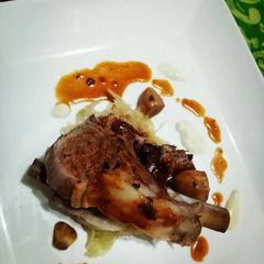 A picture of Roasted lamb rack with red wine reduc. And cream cheese melt.