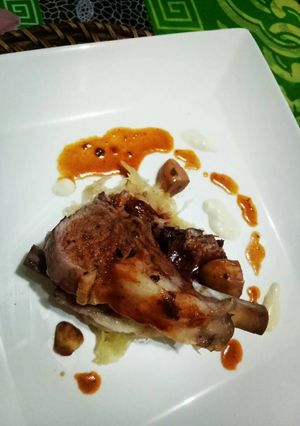 A picture of Roasted lamb rack with red wine reduc. And cream cheese melt.