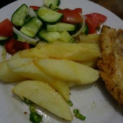 A picture of Fish and chips with cucumber salad.