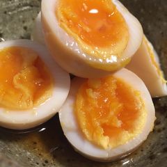 A picture of Soft boiled eggs marinated in soy sauce and mirin.