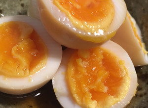 A picture of Soft boiled eggs marinated in soy sauce and mirin.
