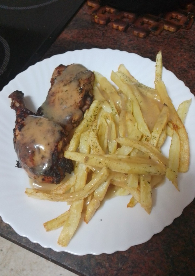 Una foto de Muslos de pollo adobados y asados en freidora de aire con papas fritas al ajillo y salsa del adobo