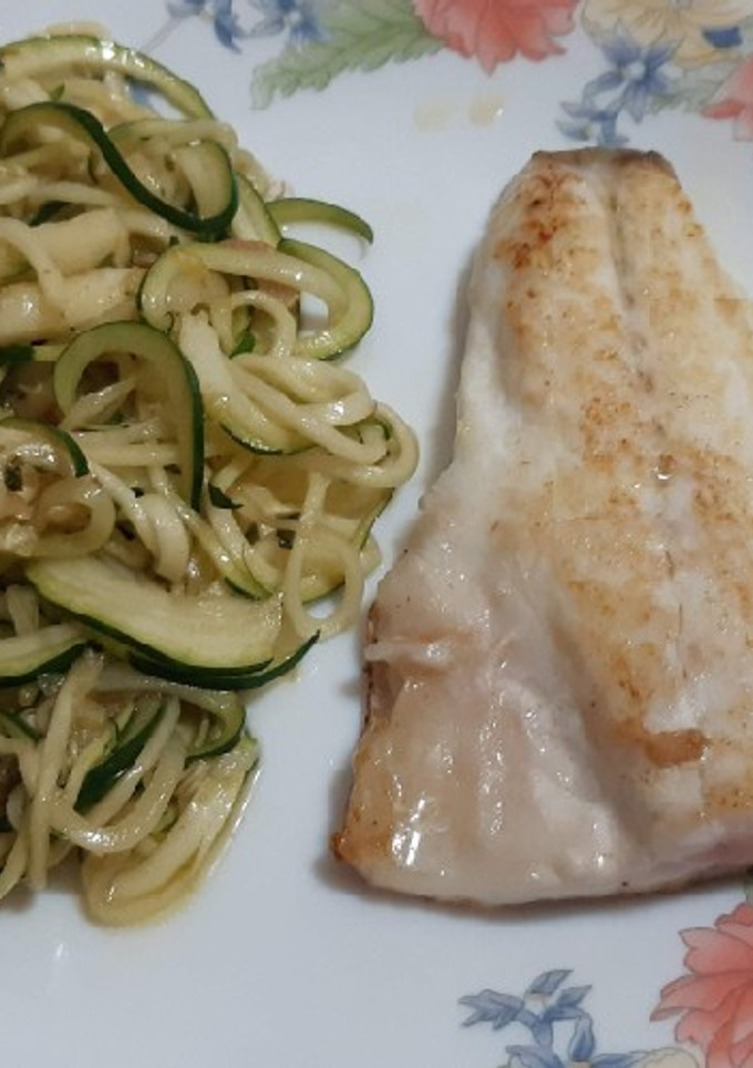 Una foto de Lubina a la plancha con espirales de calabacín al ajillo