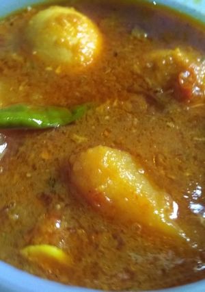 A picture of Egg curry with fried onion paste.