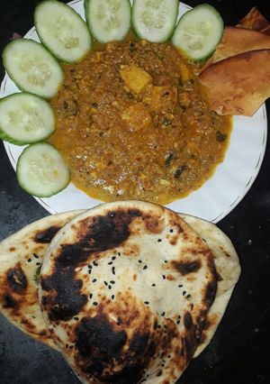 A picture of Shahi paneer with naan.