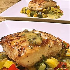 A picture of Wild halibut with lemon honey butter caper sauce and succotash.