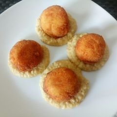 A picture of Deep fried salmon and corn balls with hummus.