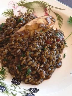 Una foto de Arroz negro con chipirones rellenos