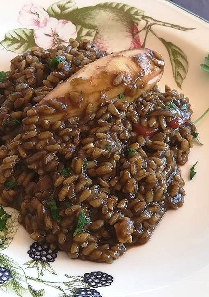 Una foto de Arroz negro con chipirones rellenos