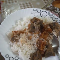 A picture of Coconut rice with goat meat stew.