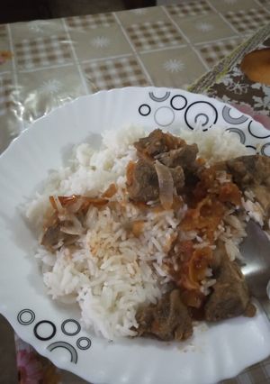 A picture of Coconut rice with goat meat stew.