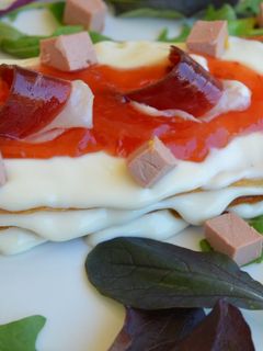 Una foto de Mil hojas de queso camembert con mermelada de tomate mousse de foie de pato y jamón de pato