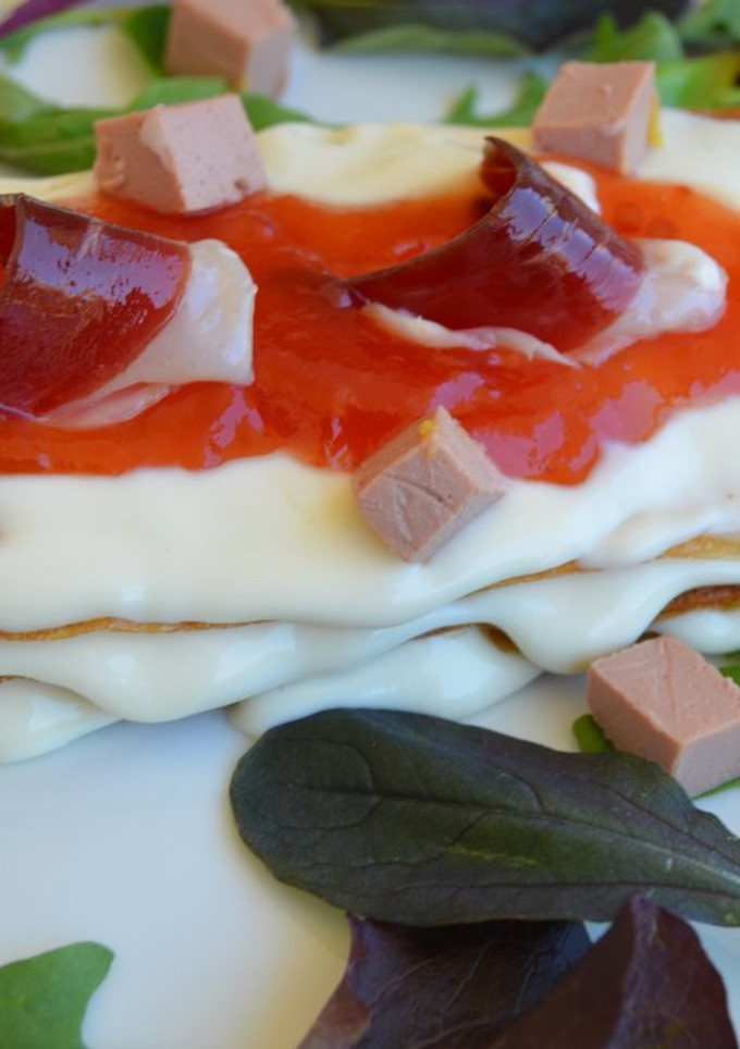 Una foto de Mil hojas de queso camembert con mermelada de tomate mousse de foie de pato y jamón de pato