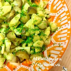 A picture of Potato salad with pickled cucumbers and green peas.