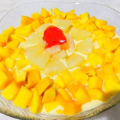 A picture of Vanilla custard with mango pineapple,apple,banana,and jelly.