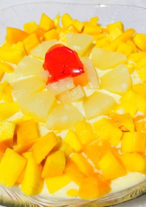 A picture of Vanilla custard with mango pineapple,apple,banana,and jelly.