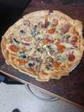 Pizza de jamón serrano, fuet, espinacas y tomate cherry