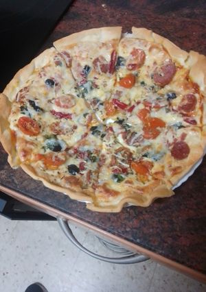 Una foto de Pizza de jamón serrano, fuet, espinacas y tomate cherry