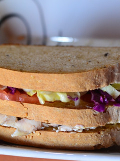 Una foto de Sándwich de pollo y verdura en pan con masa madre